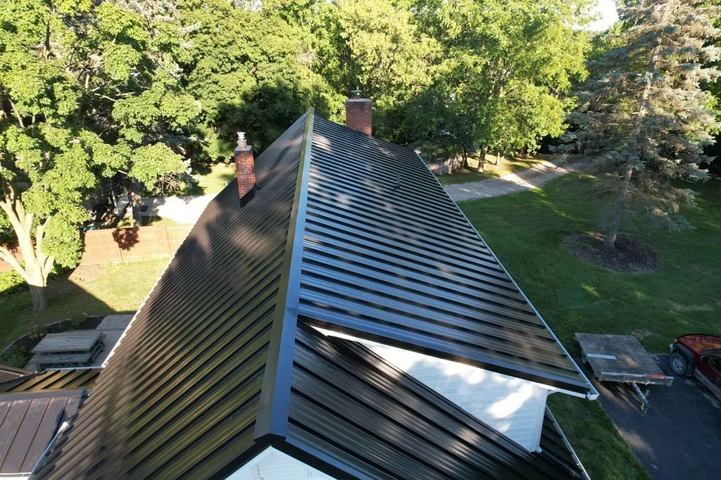 ridge view of new black standing seam metal roof replacement