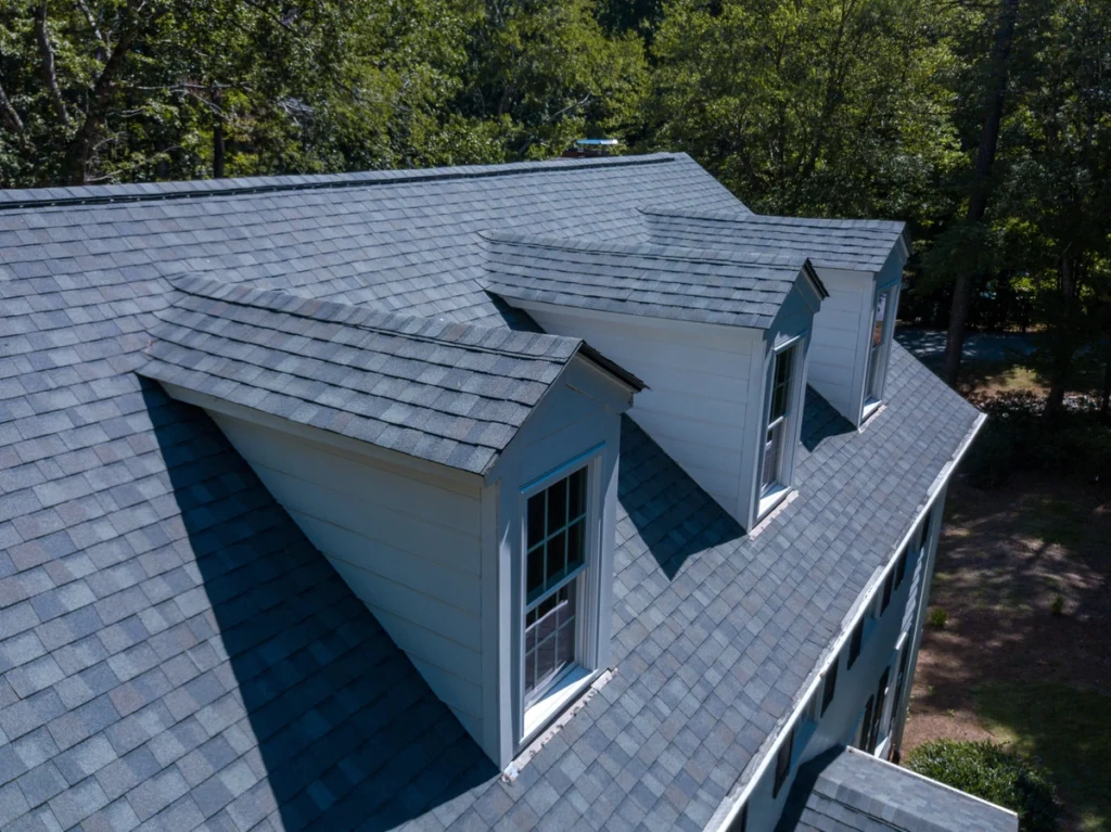 side view of asphalt roof replacement installed by shingle and metal roofing