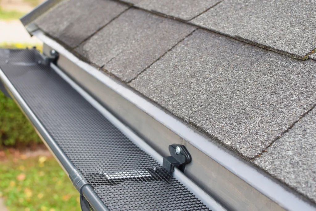 installing gutter guards for better runoff on asphalt roof