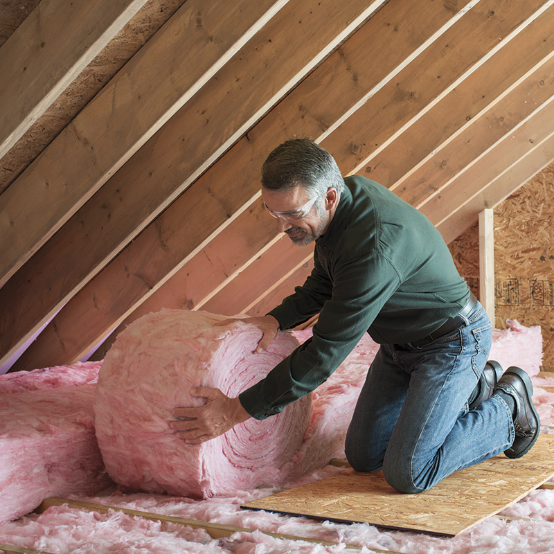 Shingle and metal employee laying down owens corning insulation in an attic