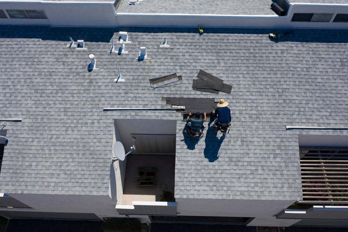 roofers inspecting and repairing the asphalt shingle roof