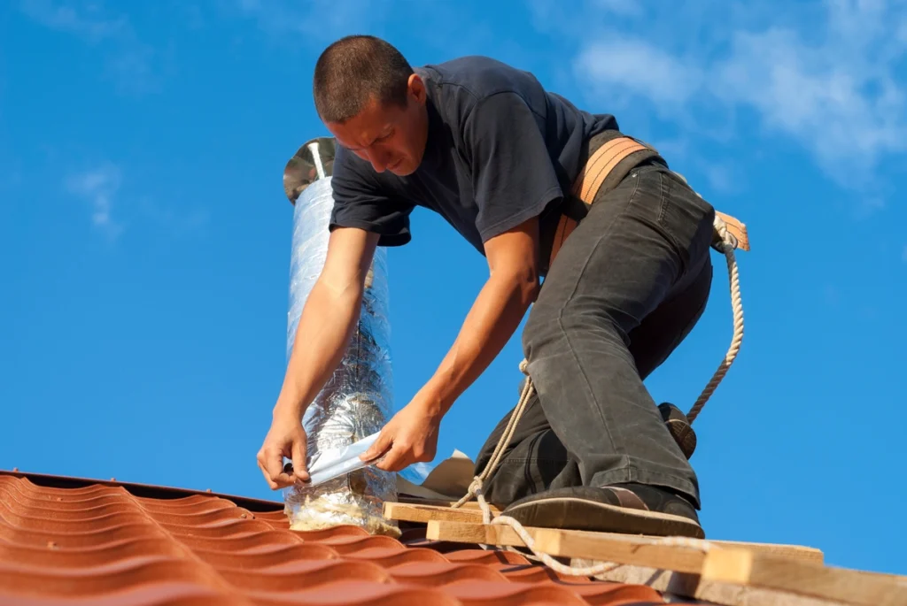 worker installing roof ventilation system on the house roof