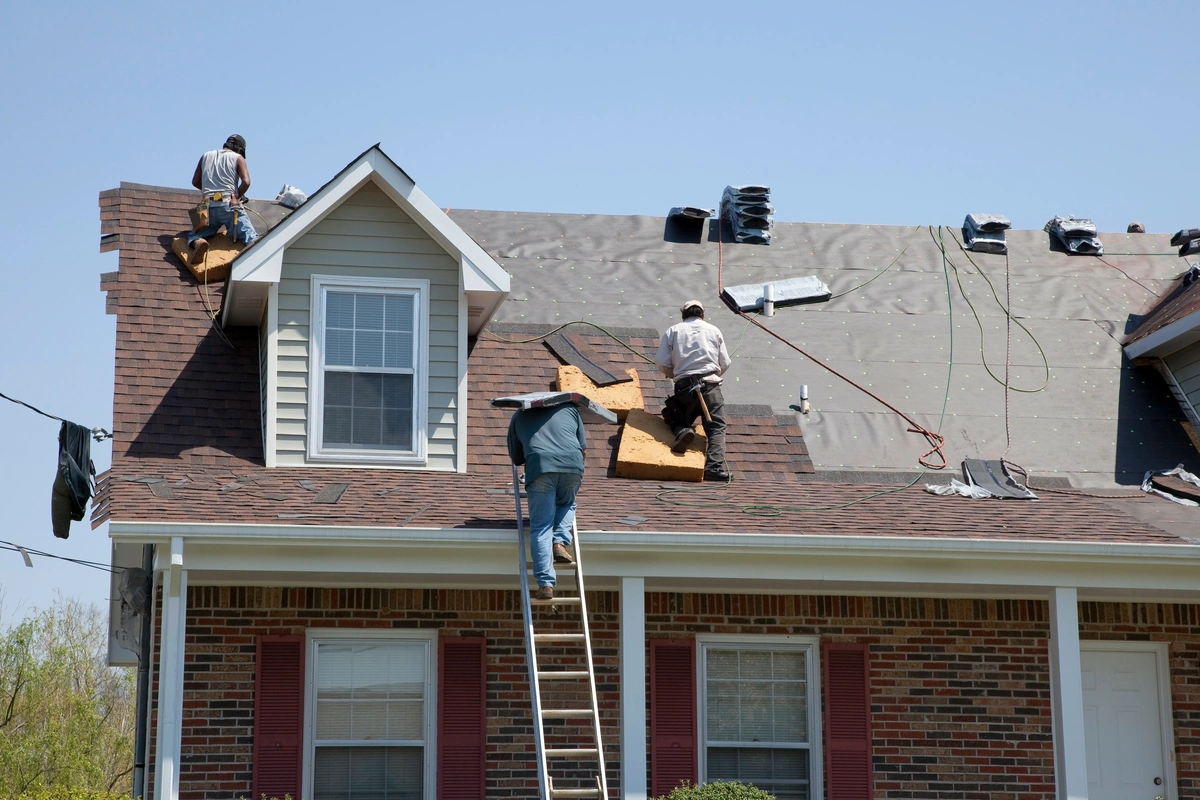 roofing contractors use ladder and tools to replace roof
