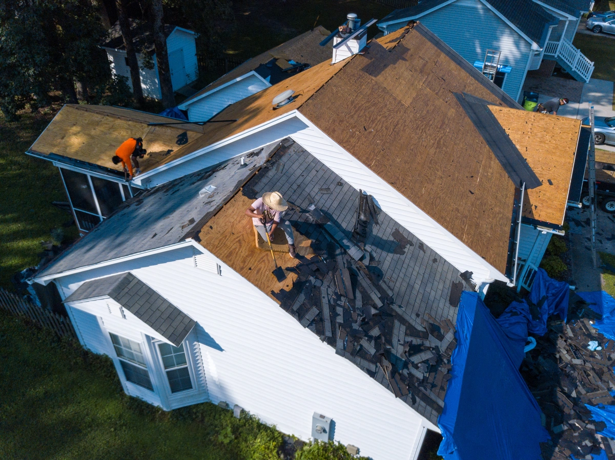 workers stripping off an old roof
