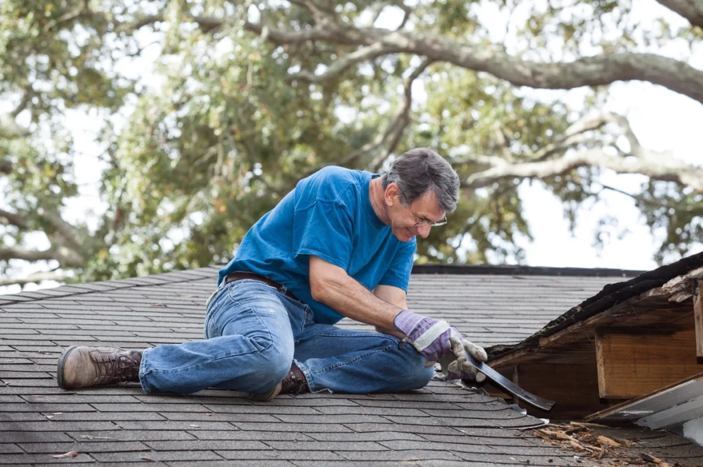 A homeowner inspects a damaged roof deck