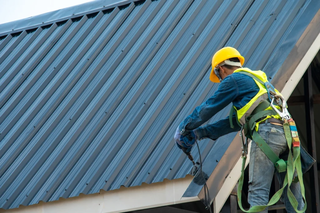 Roofing contractor installing metal roof panels.