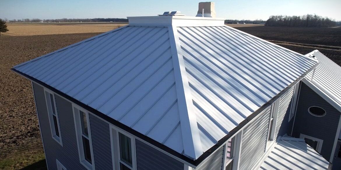 Polar white standing seam metal roofing work with black gutter guards.