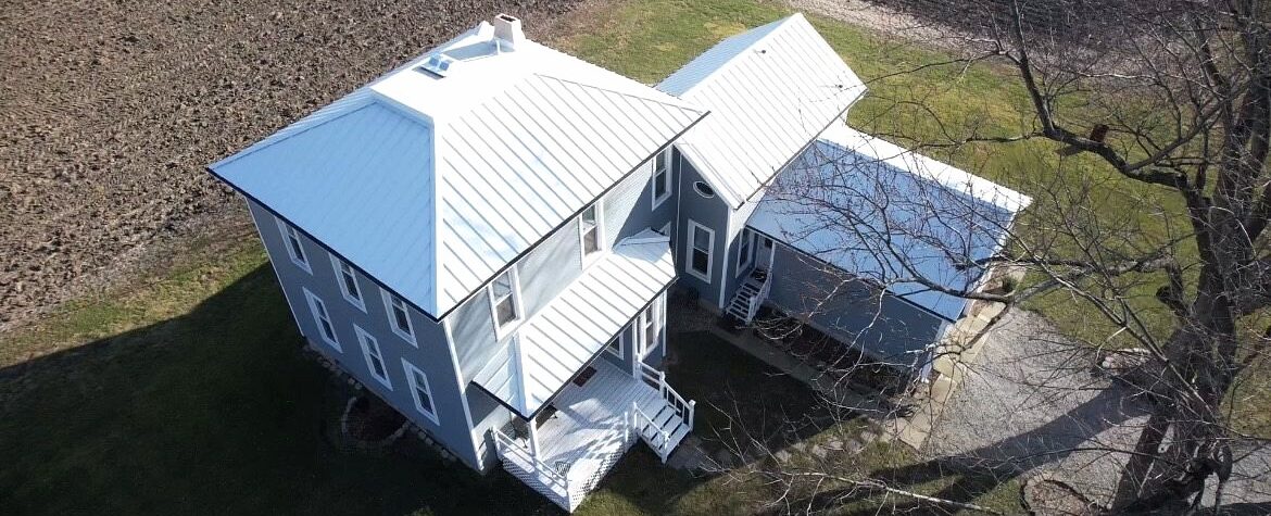 Farm house featuring brand new metal roof, custom windows and vinyl siding completed by Shingle and Metal Roofs LLC