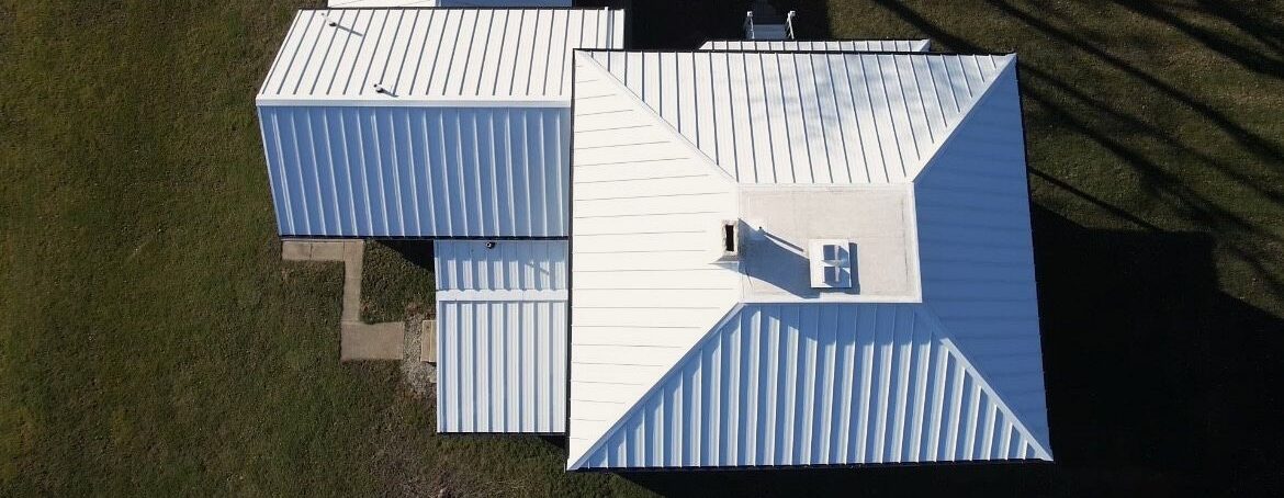 Above a brand new, expertly installed Polar white standing seam metal roof installed by Shingle and Metal Roofs LLC