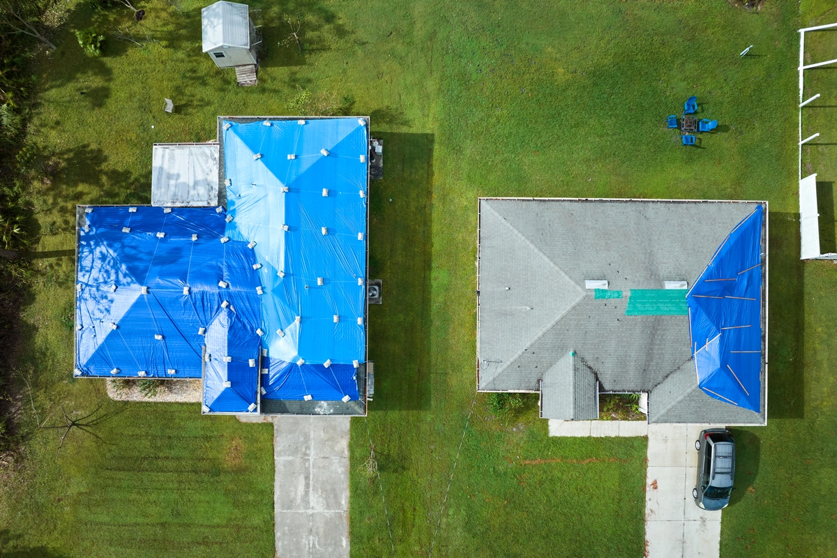 two house's aerial view with tarping