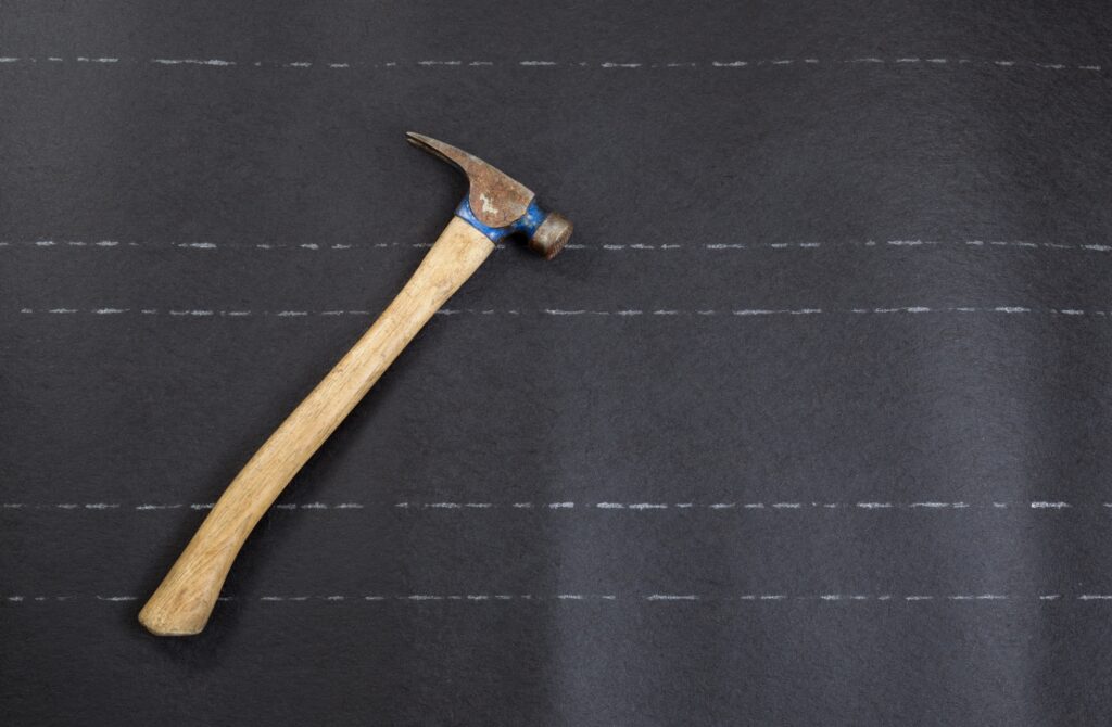 A hammer lying on a marked background, likely for precise measurement or alignment in construction or woodworking tasks