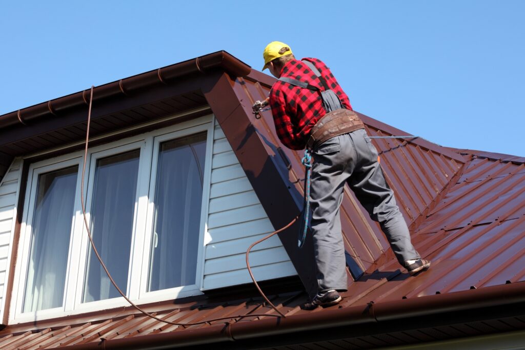 A man engaged in the repair process on a roof, working to ensure its integrity and functionality.